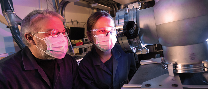Le professeur Sylvain Coulombe et Lynn Hein examinent un système de plasma à basse pression