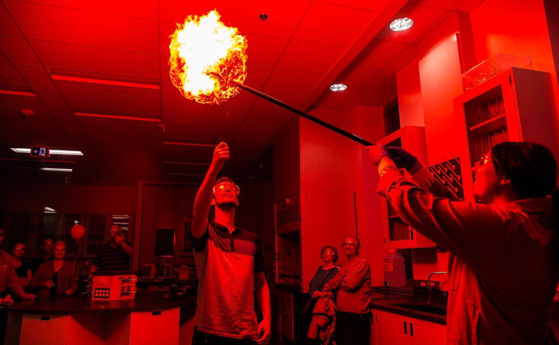 Students performing a fiery chemistry demonstration