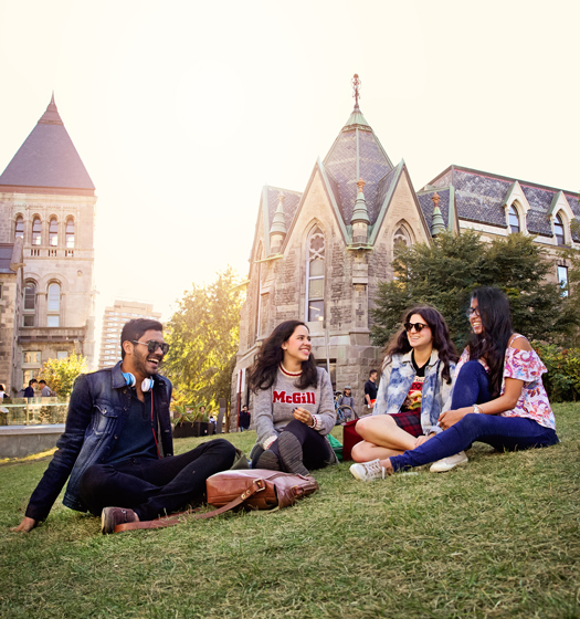 Four students sitting on the front lawn of McGill campus.